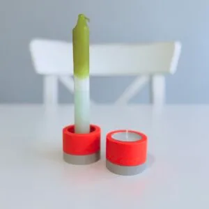 Terrazzo-Kerzenständer und Teelichthalter von Maike im Studio.Elise, grün-weiße Kerze auf weißem Tisch, Hintergrund grau.