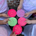 Kindergeburtstag im Studio.Elise: Kinder basteln bunte Terrazzo-Untersetzer, tragen STUDIO.ELISE Schürzen, kreative Workshop-Atmosphäre.