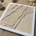 Strukturierte abstrakte beige Leinwand mit Terrazzo- und Makramee-Elementen, Workshop-Materialien im Studio Elise bei Maike.