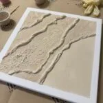 Strukturierte abstrakte beige Leinwand mit Terrazzo- und Makramee-Elementen, Workshop-Materialien im Studio Elise bei Maike.