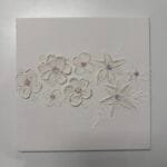 Strukturierte Kunstwerkstatt im Studio.Elise: weiße 3D-Blumen auf Leinwand, zarte Rosa- und Blautöne, Kreativkurs bei Maike.
